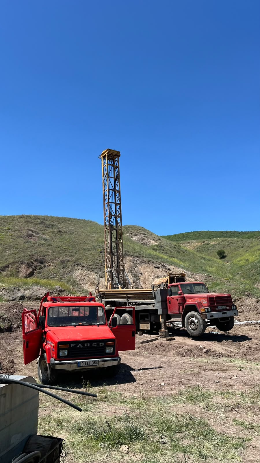 Kırsal arazide iki Cansu Sondaj aracı ve sondaj kulesi